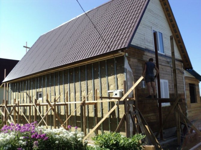 Comment attacher de la laine minérale au mur d'une maison en bois