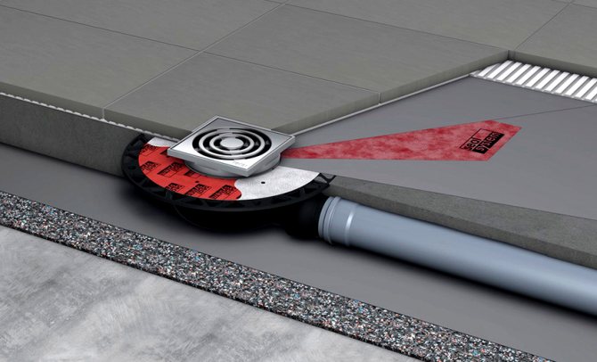 Le drain d'égout est installé selon les instructions - l'isolation thermique, l'imperméabilisation, la chape de ciment et les carreaux de sol sont posés sur le sol