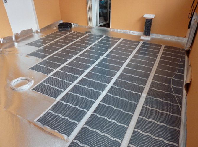 Installation de feuilles de chauffage par le sol dans un salon