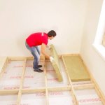 Pose d'isolant sous un plancher en bois
