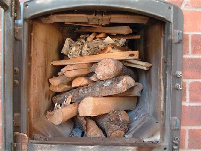 Pose de bois de chauffage dans le foyer